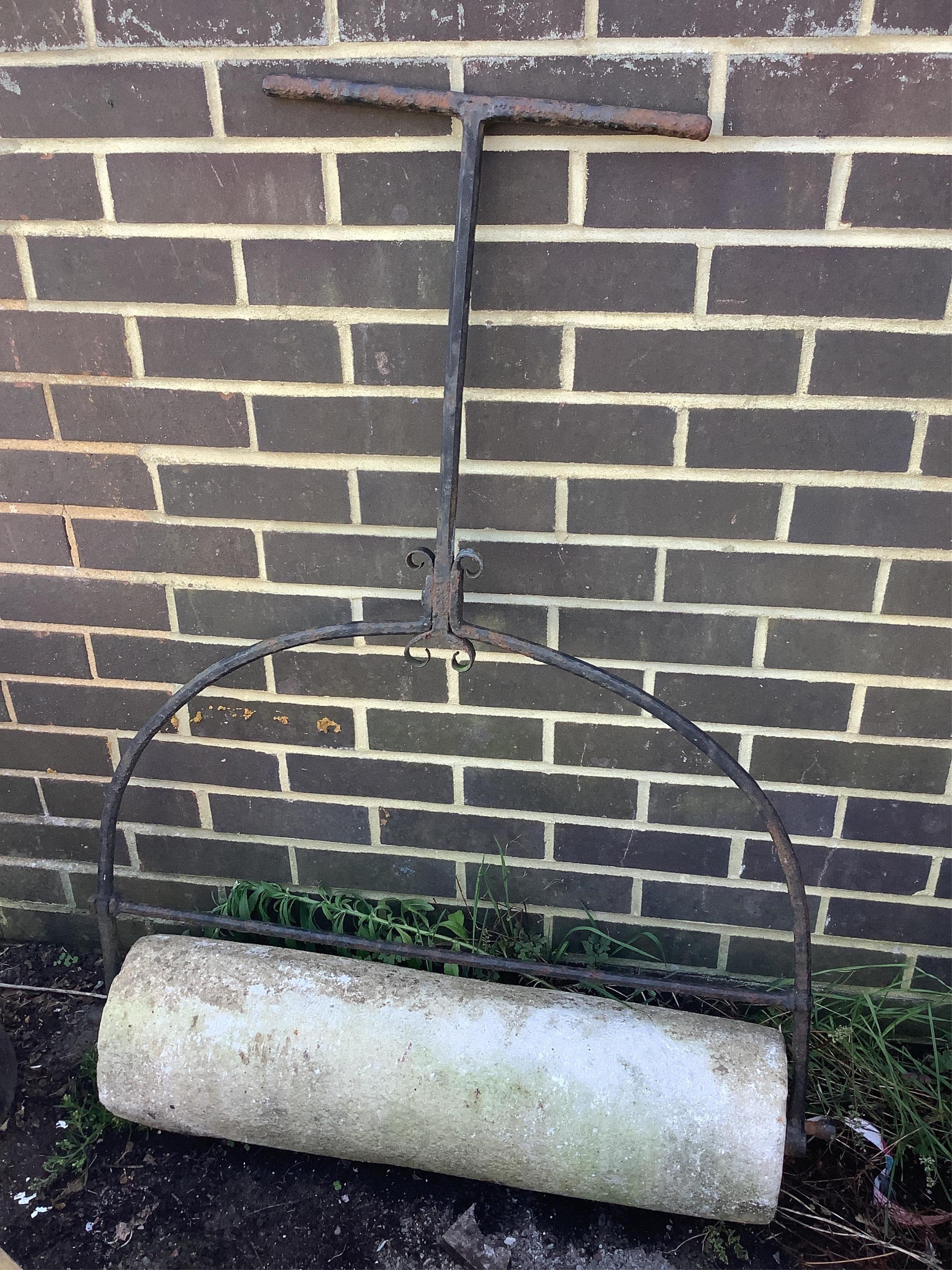 A wrought iron and reconstituted stone garden roller, height 116cm. Condition - fair